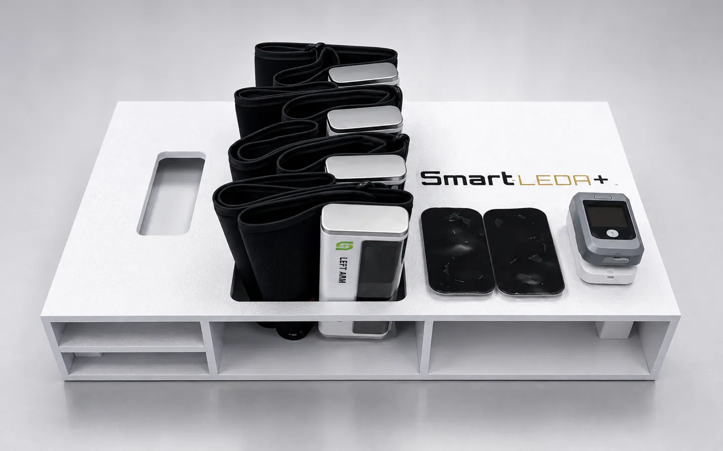 Smart-LEDA+ kit: four wireless ABI and TBI cuffs, sudomotor electrode pads, and pulse oximeter docked in the tray