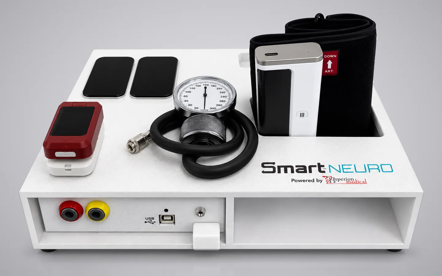 Smart-Neuro device tray holding a blood pressure cuff, pressure gauge, pulse oximeter, and two electrode pads